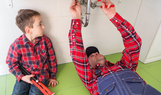 man and son working under sink