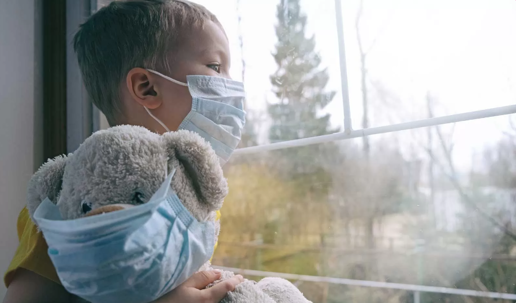 child and teddy bear wearing mask