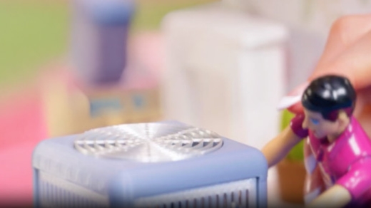 A doll technician looking at a toy ac unit.